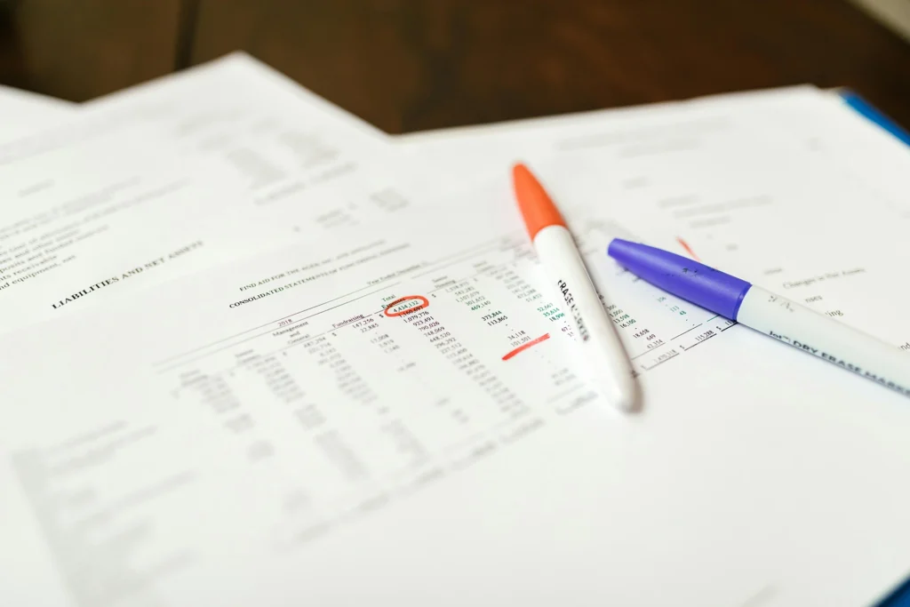 Papers on a desk next to markers
