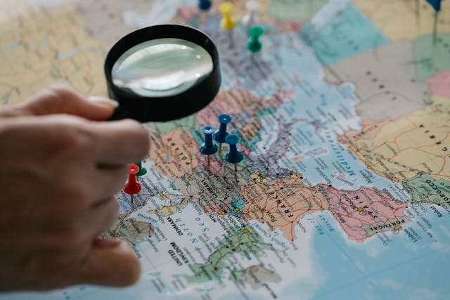 A person using a magnifying glass on a map