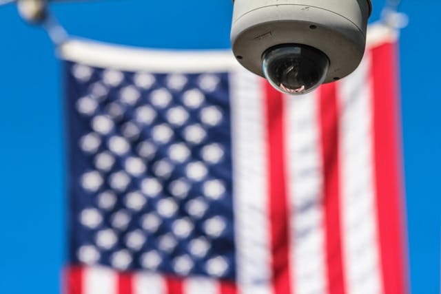 A security camera behind the American flag